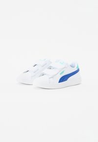 Baskets blanches avec des accents bleus et turquoise, présentant un dessus en textile lisse et des bandes Velcro sécurisées pour un maintien facile.