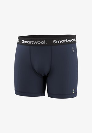 Marineblauwe Smartwool boxershorts met een zwarte tailleband met het witte Smartwool-logo en een klein kleurrijk label bij de zoom.
