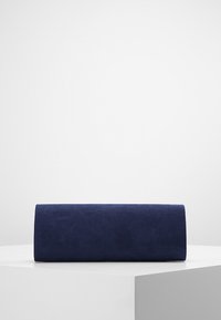Pochette en suede bleu marine ; forme rectangulaire avec une texture lisse ; sans matériel visible ni embellissements ; design minimaliste.