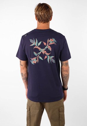 T-shirt en coton bleu marine avec un design floral coloré au dos, à manches courtes et à coupe standard.
