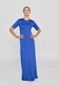 Maxikleid aus einfarbigem blauen Stoff mit rundem Ausschnitt, kurzen Ärmeln und einer figurbetonten Passform. Es hat eine glatte Textur und ist bodenlang.