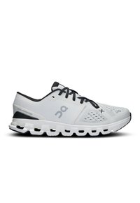 Baskets de sport blanches avec une tige en mesh, accents noirs et col rembourré. Elles présentent une semelle rembourrée avec un design segmenté distinct.