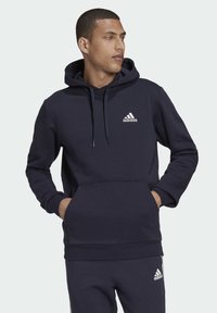 adidas Sportswear ESSENTIALS FLEECE - Jersey con capucha - blue