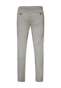 Lichtgrijze broek van stof met een gladde textuur. Heeft een elastische tailleband en twee achterzakken met zwarte knoopaccenten.