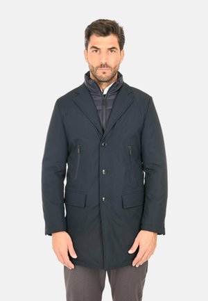 Cappotto blu navy, resistente all'acqua, con un design su misura, revers a punte, due tasche frontali e un strato interno con zip per il calore.