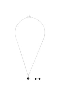 Collana con pendente in cristallo nero e catena in argento, caratterizzata da un ciondolo rotondo. Accompagnata da orecchini a bottone neri abbinati.