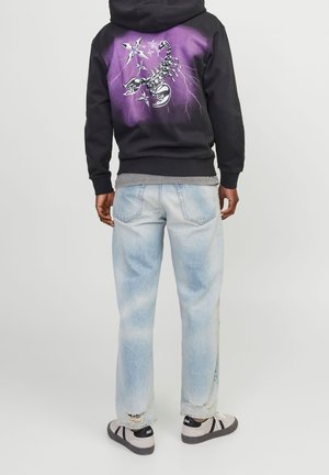 Black hoodie with a purple graphic design featuring a scorpion and stars. Paired with light blue distressed jeans and gray sneakers.