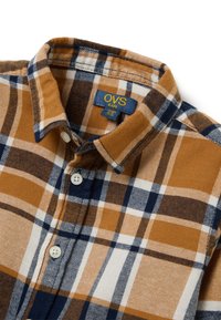 Bruine en marineblauwe geruite overhemd met witte accenten, button-down kraag en witte knopen. Gemaakt van zacht flanel. OVS kids label zichtbaar.