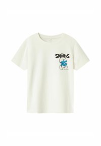 Camiseta de algodón blanca con un gráfico impreso de un pitufo azul y el texto negro "LOS PITUFOS" en la parte frontal, mangas cortas y cuello redondo.