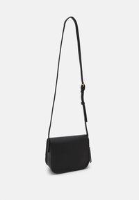 Svart crossbody-väska i slätt material, med rektangulär form, lång justerbar rem och en diskret tofsdetalj.