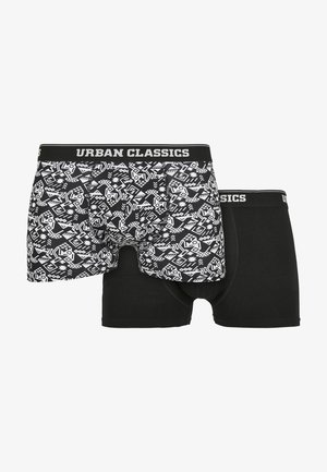 Černobílá sada pánských trenýrek, která obsahuje jeden pár s geometrickými vzory a druhý v jednobarevné černé barvě, obě s páskem "URBAN CLASSICS".