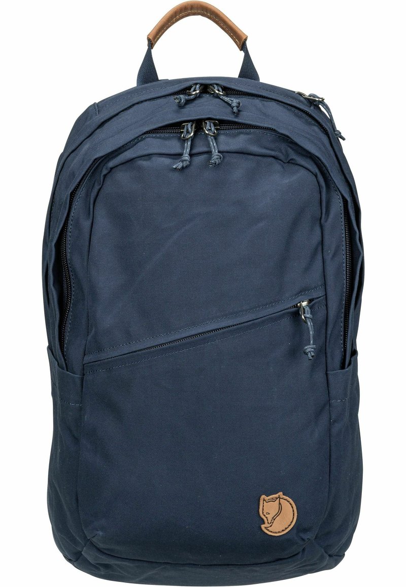 Sac à dos bleu marine en tissu résistant, doté d'une poignée en cuir marron, de deux compartiments zippés et d'un logo de renard sur le devant.