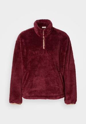 Bordeauxfarbener Fleecepullover mit hohem Kragen, halbem Reißverschluss vorne und weicher Textur; mit beigen Akzenten am Kragen und den Bündchen.