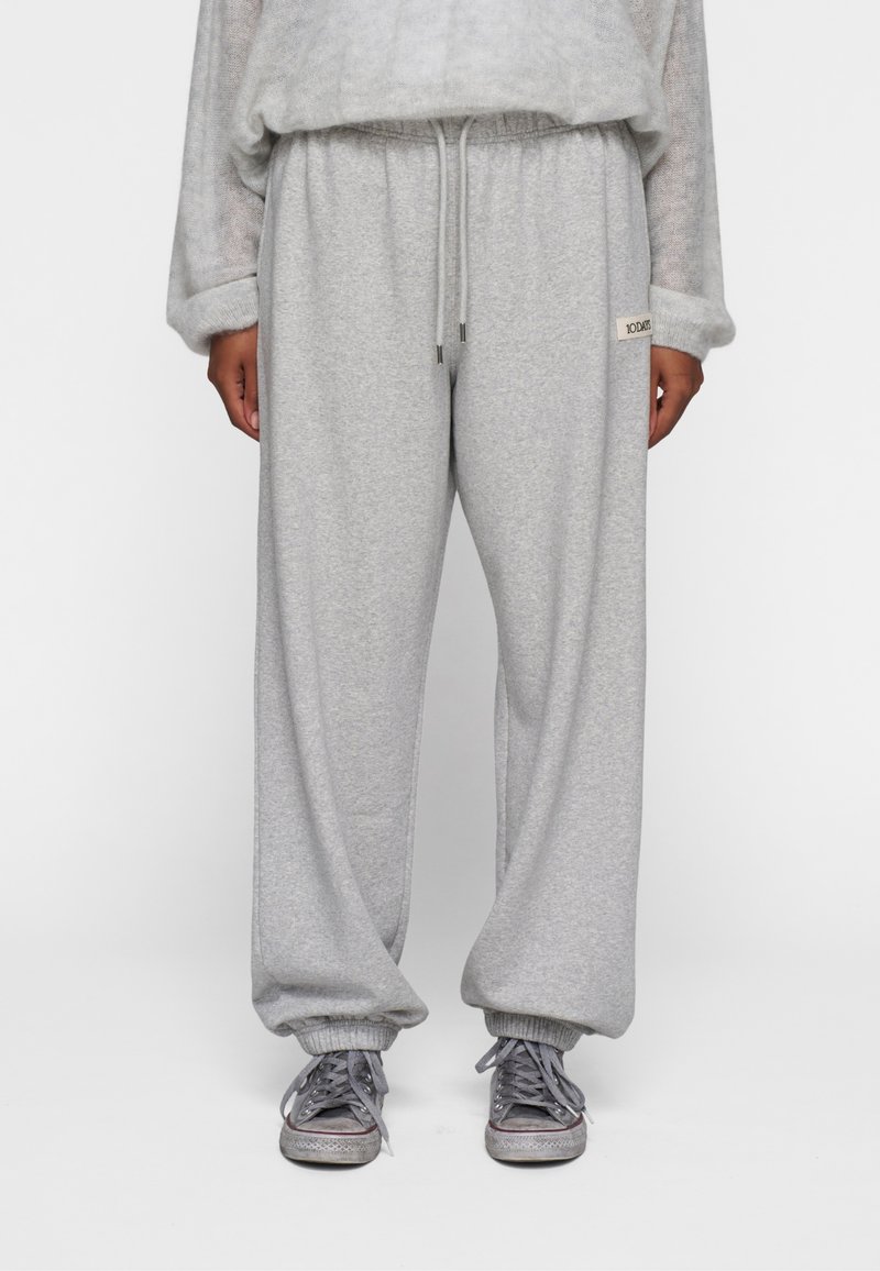 Grå fleece sweatpants med en afslappet pasform, elastisk talje med snor og ribbede manchetter. Har et lille logo-patch på siden.