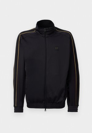 Svart zip-up treningsjakke med gullpiping på ermene og skuldrene, elastiske mansjetter og kant, samt liten EA7-logo på brystet.