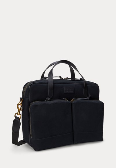 Mala para laptop em tecido preto com textura suave, bolsos frontais com fecho duplo, alças superiores, tira de ombro destacável e detalhes em metal dourado.