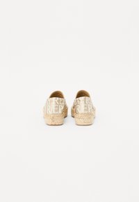 Espadrillas beige chiaro con stampa del logo bianco a contrasto sulla tomaia in tessuto e suola in juta intrecciata. Schiena chiusa e punta rotonda.