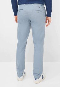 Pantaloni di cotone azzurri con taglio dritto, dotati di due tasche posteriori con bottoni e una texture liscia.