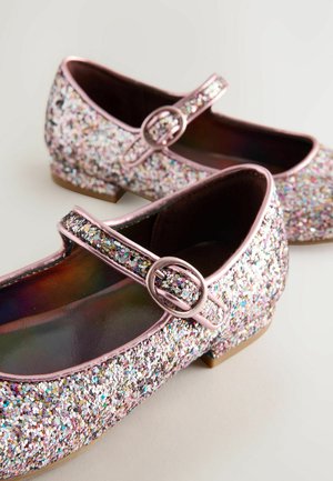 Bailarinas brillantes de color rosa con punta redondeada y una correa que presenta una hebilla metálica. La parte superior está cubierta de lentejuelas multicolores.