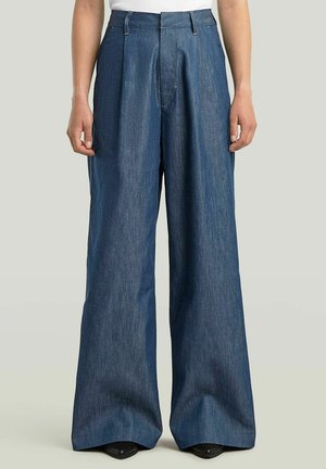 Wide-leg denim trousers in dark blue, featuring a high waist, pleat detailing, and a smooth fabric texture.