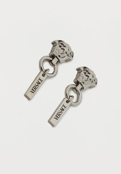 Ζευγάρι σκουλαρίκια από μεταλλικό υλικό σε ασημί τόνο με καρφάκια κεφαλής Μέδουσας, διπλούς κυκλικούς κρίκους και ορθογώνιες μπάρες με χαραγμένη την επιγραφή "VERSACE".