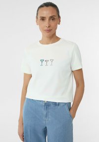 Witte katoenen t-shirt met korte mouwen, met geborduurde cocktailglazen in blauw en pastelkleuren op de voorkant. Casual pasvorm en ronde halslijn.