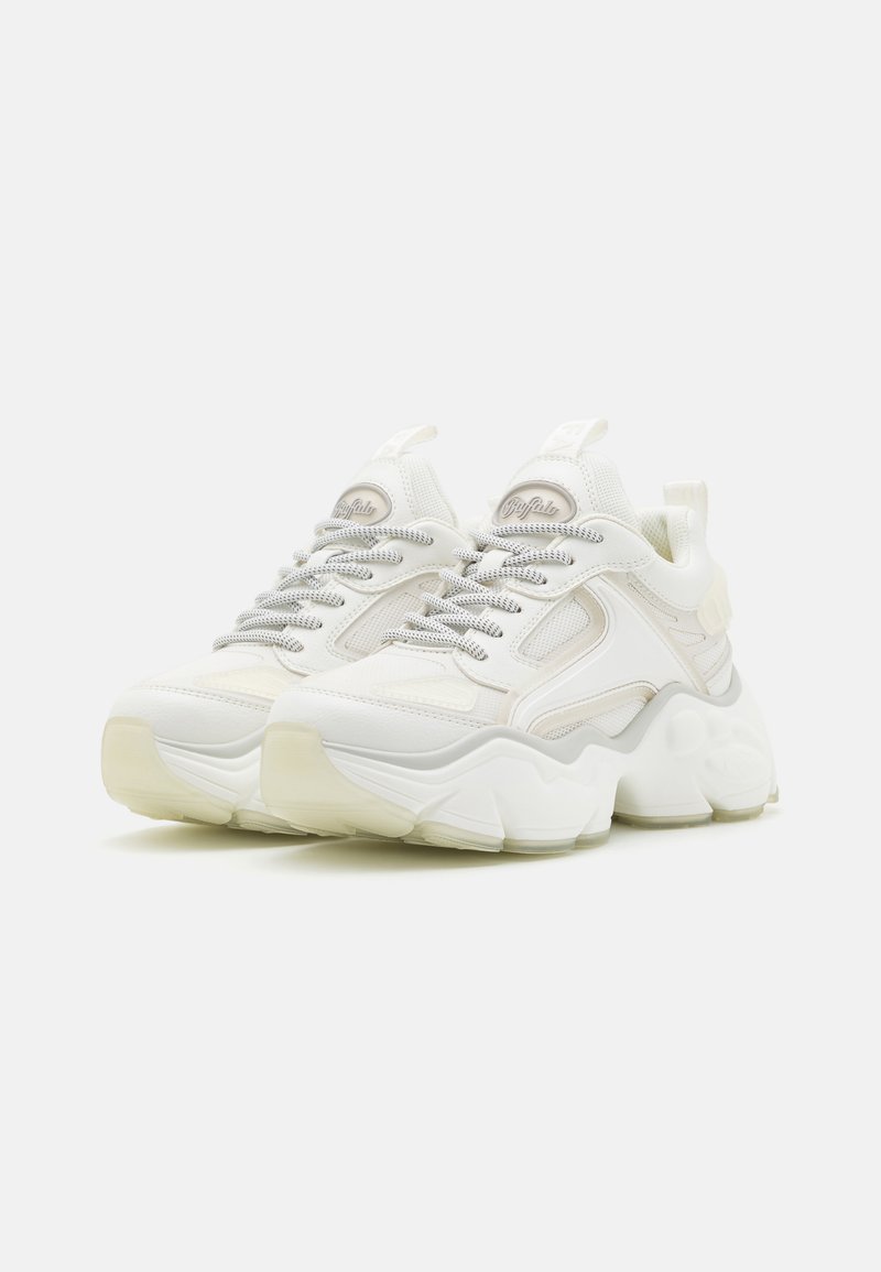 Białe trampki o teksturowanej cholewce, wyraźnym, dobrze wyściełanym kołnierzu oraz grubym, zakrzywionym podbiciu z akcentami marki. Jasny i minimalistyczny design.