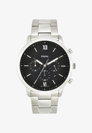 Montre-bracelet Fossil argentée avec cadran noir, trois sous-cadrans, guichet date, chiffres romains aux positions 12 et 6, et bracelet à maillons en métal.