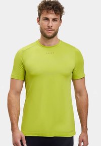 Kortärmelig, felgroene sportshirt gemaakt van glad, rekbaar materiaal met een aansluitend ontwerp en een subtiel logo op de borst.