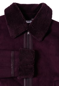 Giacca bordeaux con colletto in ecopelliccia e finitura testurizzata. Presenta una chiusura con zip e dettagli in pelle liscia nei polsi.