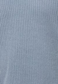 Jasnoniebieski sweter dzianinowy o teksturowanym wzorze, z poziomym prążkowaniem i miękkim, oddychającym materiałem.