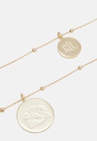 Gold-tone necklace featuring two pendants: one with "RLL" engraving and another displaying a crowned coat of arms design. Chain includes spherical accents.