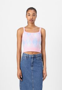 Pink and blue argyle knit crop top with thin straps, paired with a high-waisted denim skirt. Texture is soft, with visible ribbed hem.