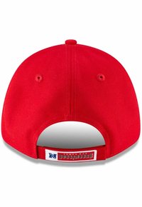 Rdeča bejzbol kapa s ravnim robom in nastavljivim trakom. Ima teksturo iz tkanine in blagovno oznako, ki prikazuje "Tampa Bay Buccaneers."
