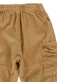 Katoenen corduroy broek in tan kleur met een elastische tailleband, zij cargo zakken en een ribbelstructuur over de gehele lengte. Gestikte naden zijn zichtbaar.