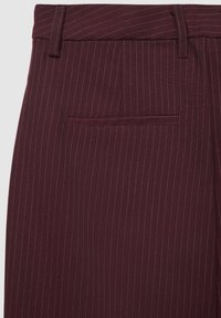 Pantalon bordeaux à fines rayures avec devant plat, passants de ceinture et poche arrière. Le tissu présente une texture fine avec des coutures contrastées.