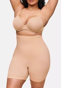 Beiger nahtloser Shapewear-Body mit hoher Taille, glatter Textur und verstellbaren Trägern, entworfen für Körperformung und Unterstützung.