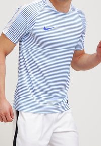 Camiseta atlética azul claro con rayas horizontales azules, cuello redondo, mangas cortas y un pequeño logo azul de Nike en el pecho.