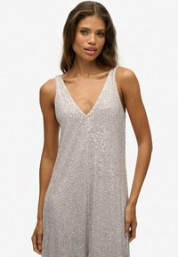 Schimmerndes silbernes Kleid mit tiefem V-Ausschnitt, ärmellosem Design, Paillettenstruktur und gerader Silhouette, das bis zur Mitte der Wade reicht.