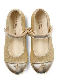 Złote brokatowe buty Mary Jane z metalicznym złotym czubkiem i paskiem. Posiadają logo na czubku oraz gładkie, wewnętrzne wykończenie.