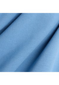 Tela de algodón azul claro con una textura suave, que presenta un patrón acanalado y pliegues ligeros. El material parece suave y elástico.