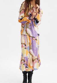 Langarmtop en bijpassende rok in kleurrijke abstracte print met gele, roze, paarse en zwarte accenten. Zachte, tekstuurlijke stof.