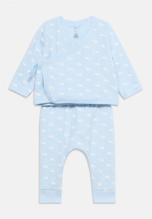 Ensemble nouveau-né bleu clair composé de deux pièces avec manches longues, haut à nouer sur le côté, et motif de baleine blanche sur le haut et le pantalon.