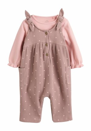 Tricou roz cu mânecă lungă din material ribbed sub salopetă mov ribbed cu mici imprimeuri de inimioare, nasturi în față, legături pe umeri și buzunare laterale pentru un bebeluș.