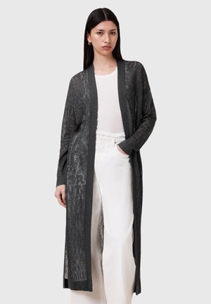 Lange, open voorkardigan in donkergrijs, met een textuurpatroon, lange mouwen en zijsplitten, gedragen over een licht topje en crèmekleurige broek.