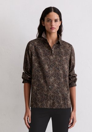 Brązowa koszula w kwiatowy wzór z kołnierzykiem, zapięciem na guziki z przodu i podwiniętymi rękawami. Wykonana z lekkiego materiału o gładkiej fakturze.