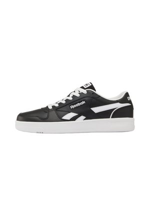 Niskie czarno-białe buty sportowe Reebok z białymi sznurówkami, logo po bokach i na języku oraz grubą białą podeszwą.
