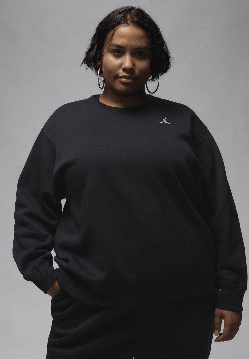 Sort sweatshirt med rund halsudskæring, afslappet pasform og ribbede manchetter. Har et lille hvidt Jumpman-logo på brystet. Blød tekstur.