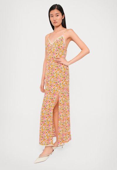Vestido maxi floral en tonos rosa y amarillo, con un escote en V profundo, tirantes finos, una abertura hasta el muslo y una tela ligera.