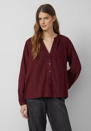 Bordeauxrode blouse met lange mouwen, knoopsluiting, V-hals, geplooide kraag en losse pasvorm. Lichtgewicht stof met een gladde textuur.